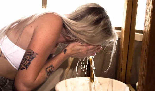young woman washing her face due to her acne issue. Using MISMO Anti-Acne bundle. 