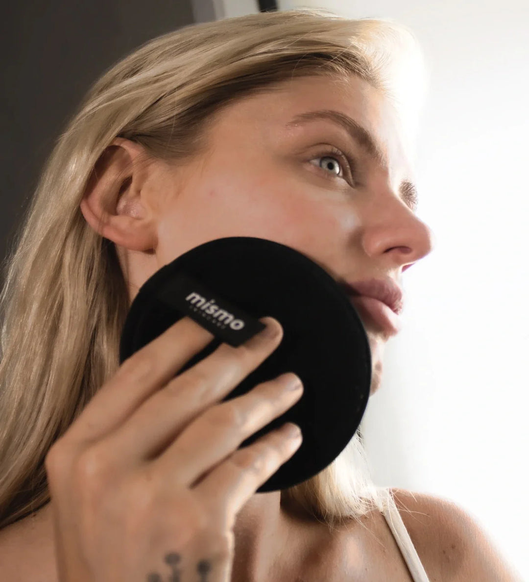 microfibre face cleanser being used by a young blonde woman in conjunction with a natural cleansing milk 