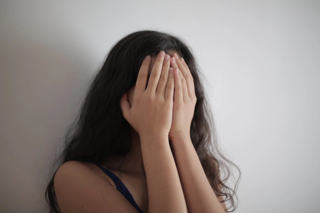 woman with rosacea hiding face 