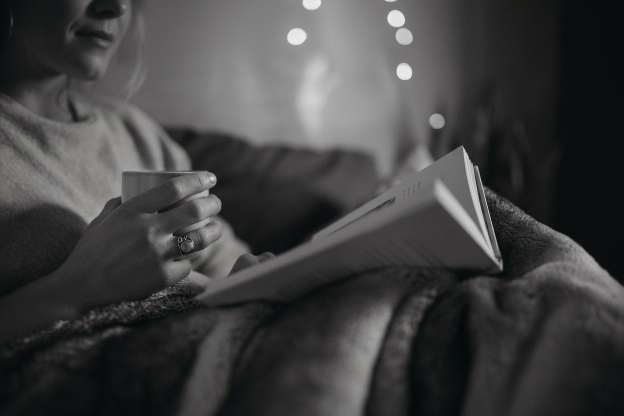 Person reading a book and holding a tea